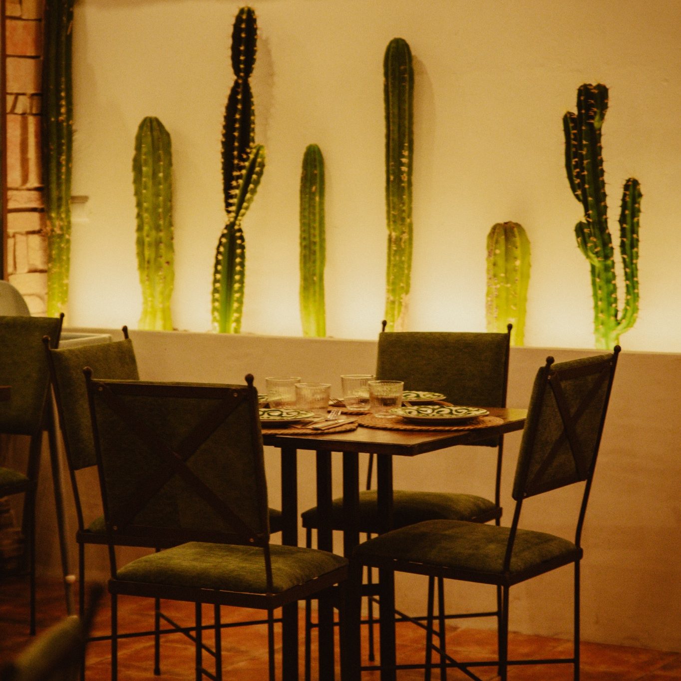 Mesa y decoración mexicana en Casa Milpa Detalle de una mesa de Casa Milpa rodeada de cactus y elementos decorativos mexicanos.